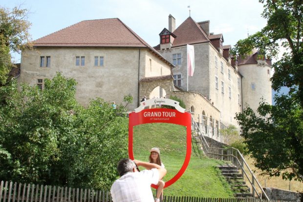 Un uomo immortala la figlia nella postazione fotografica del Grand Tour davanti al castello di Gruyères 